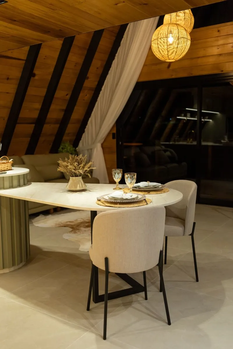Mesa de jantar posta sob as luminárias de palha