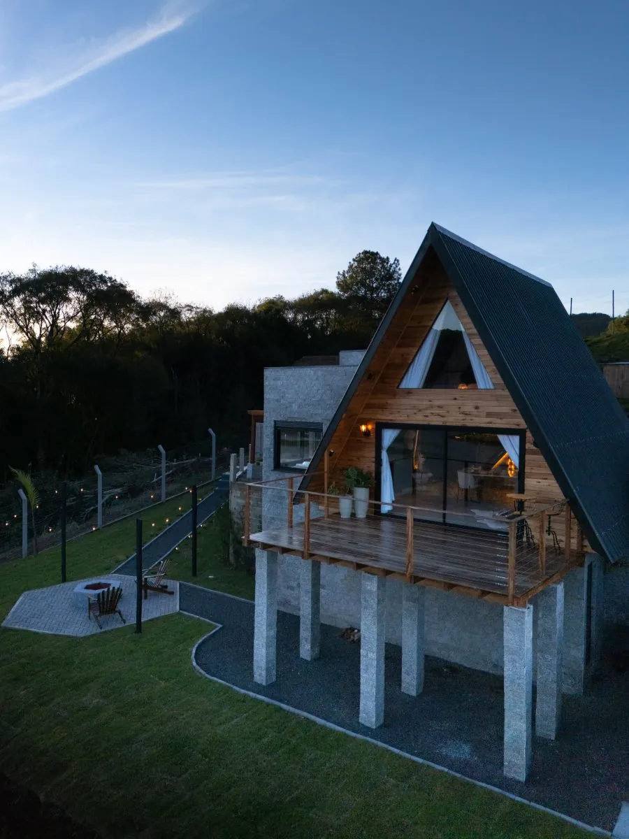 A cabana A-frame ao entardecer, com a sacada voltada para o lago